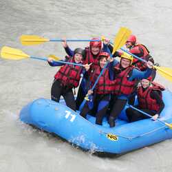 A group of people white water rafting