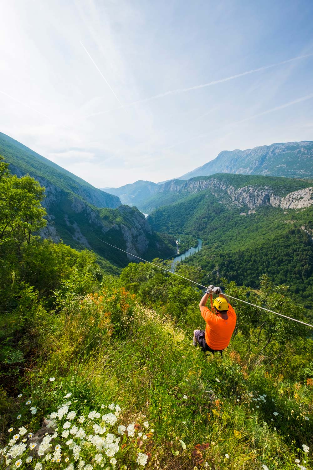 A person ziplinling across the Cetina gorge
