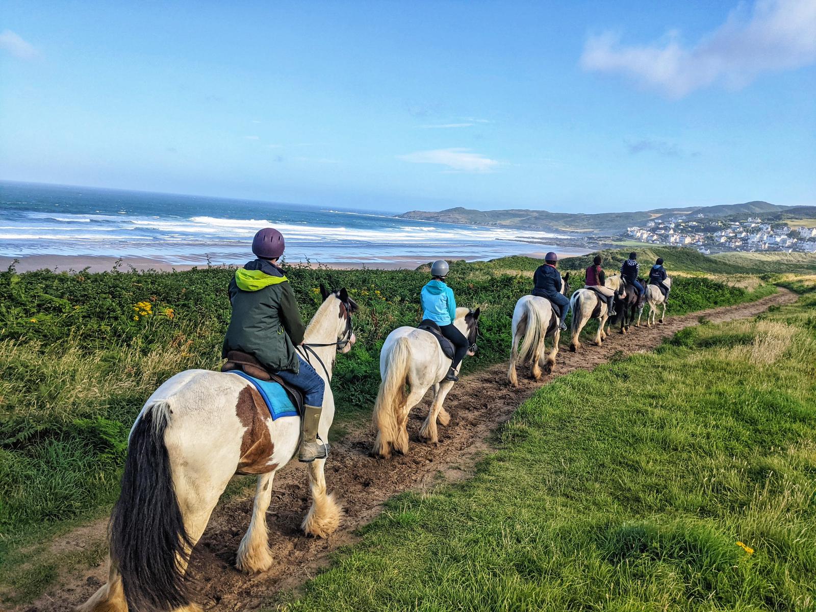 Horse trekking in North Devon showing a few riders with the sea in the background